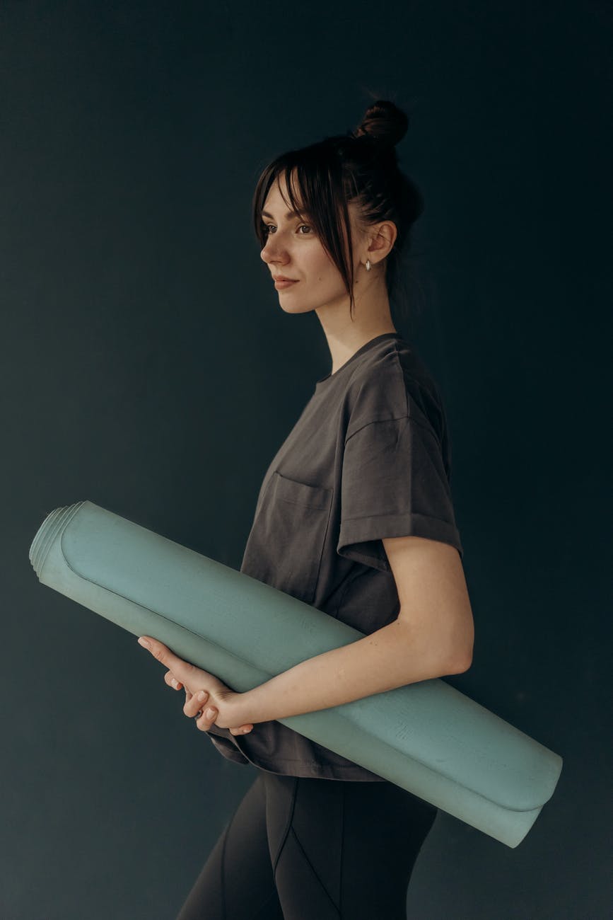 woman holding a yoga mat